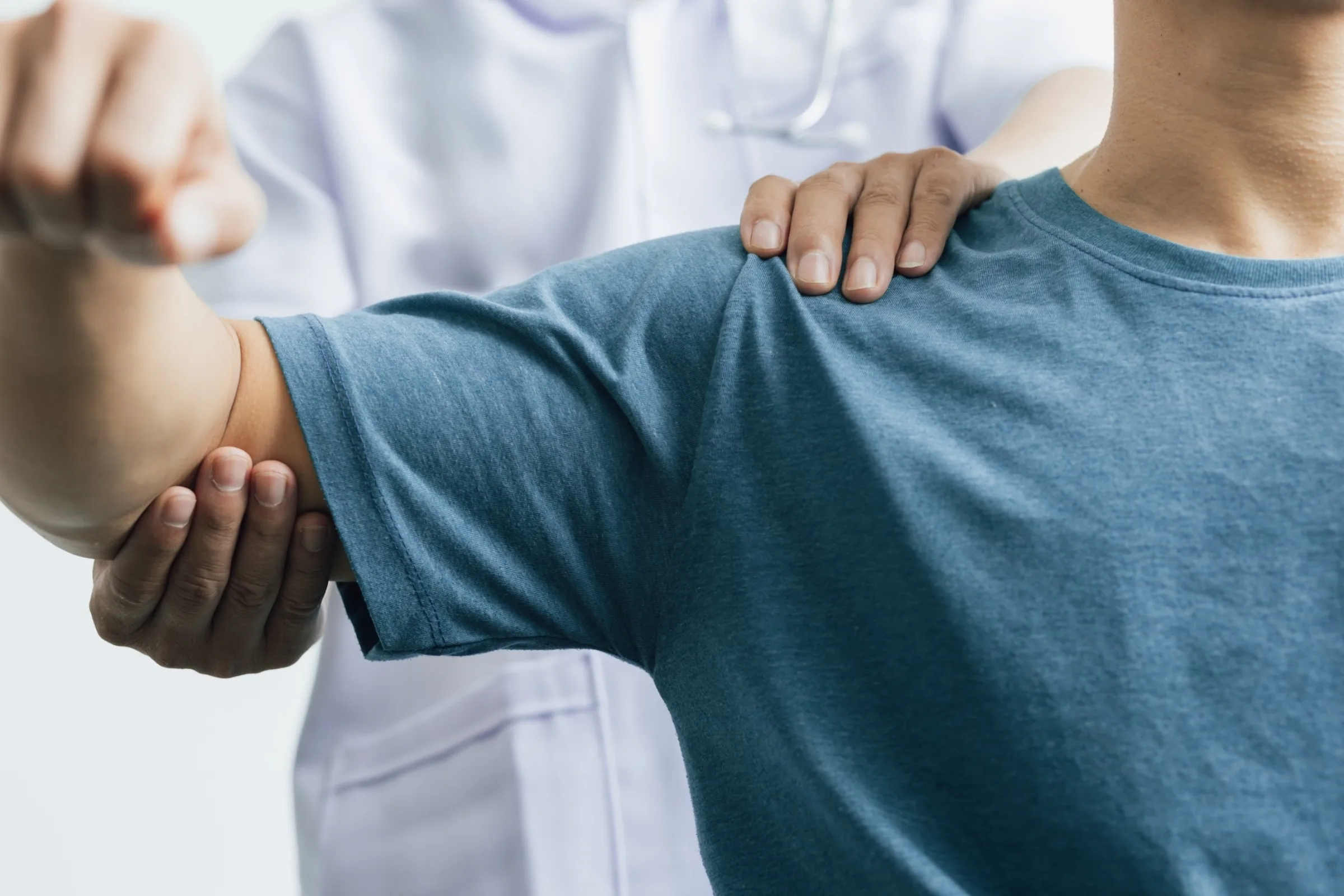 Person extending one arm while a hand rests on the shoulder